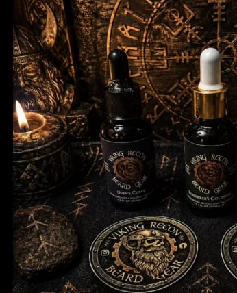 Candlelit Viking Recon display on rune cloth — bottles beside the brass medallion.